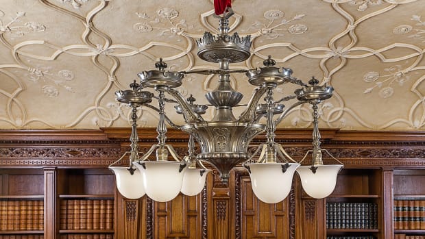 The solid brass replica chandelier in the library has hand-blown glass shades and is plated with zinc and antiqued to match the pewter finish of the original.