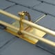 Alpine SnowGuards’ model # 502 brass two-pipe snow guard is shown on a synthetic slate roof.