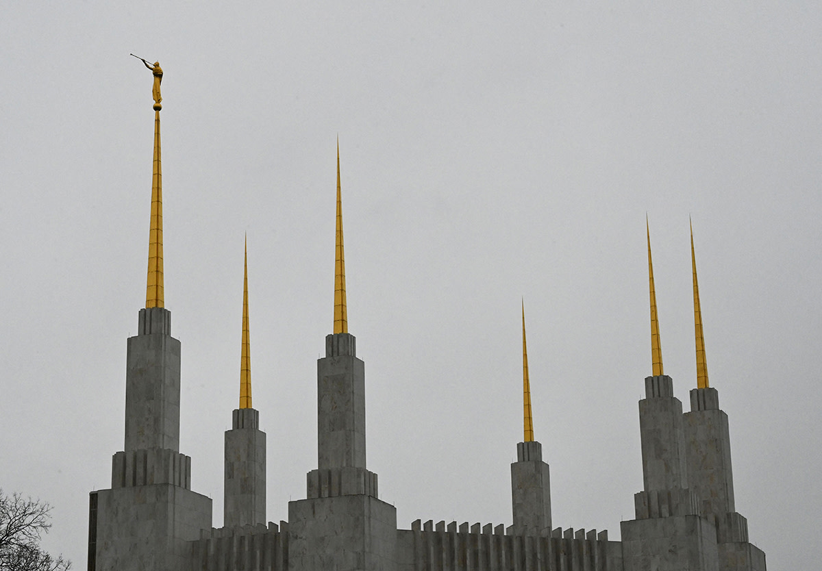 The angel Moroni is seen above the temple of the Church of Jesus Christ of Latter-Day Saints in Kensington, Maryland, near Washington, DC, April 18, 2022. - Like something out of a science fiction novel, with its six golden spires and pristine white walls, the Mormon Temple in Washington, DC, has intrigued those who have seen it for decades but have never been able to enter it. Their curiosity will soon be satisfied: for the first time in almost half a century, the temple will open its doors to the public. (Photo by EVA HAMBACH/AFP via Getty Images)