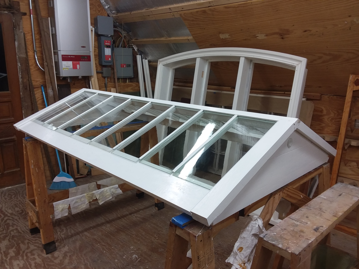 Sally Fishburn restored the skylight from the Justin Smith Morrill Homestead in Strafford, Vermont, shown in her ﬁnishing room with a restored frame from St. Peter’s Episcopal Church behind it.