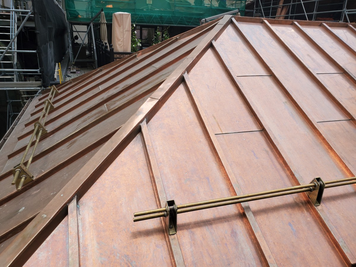 A copper batten seam roof with custom bronze snow guards by Heather & Little Limited at a private club in Ontario, Canada.