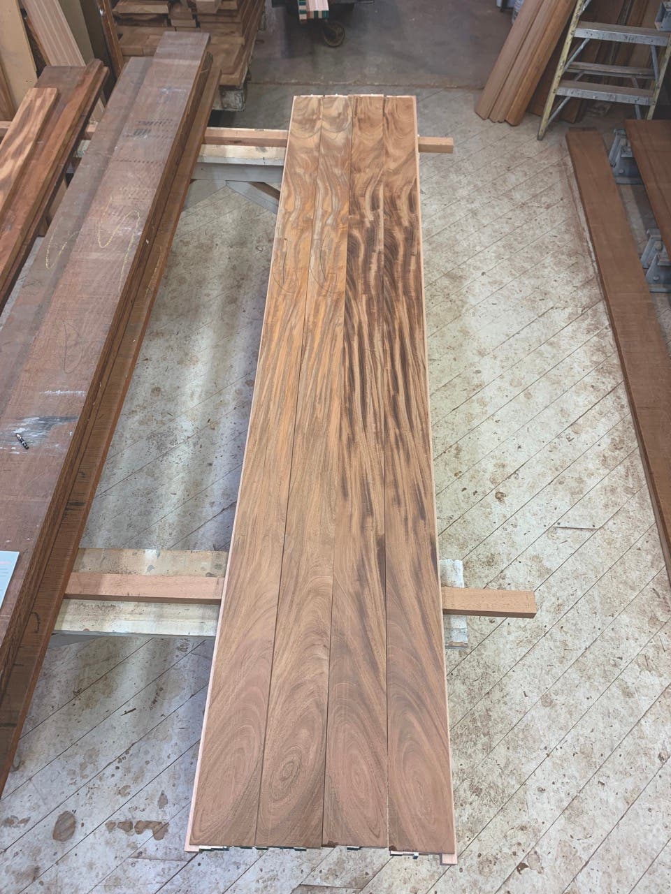 Book-matched stile components are sorted and arranged for a set of double doors. Each piece was re-sawn from the same board and arranged so the components of each door mirror each other. Note the directional grain contrasts differently from one side of the board to the other.