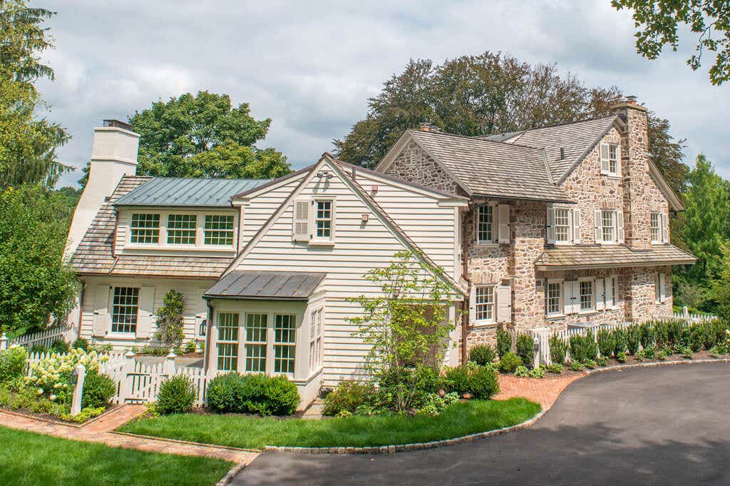 timberlane-gallery-white-panel-louver-shutters-tan-stone-house-side-angled.jpg